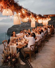 a group of people sitting around a table with food and drinks on top of it