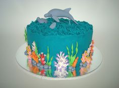 a blue cake decorated with sea animals and corals