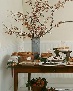 a table topped with lots of desserts next to a vase filled with flowers