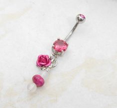 "14g surgical steel belly ring features natural rose quartz and rhodonite gemstone dangle accented with matching pink rose charm. Belly ring measures 1 7/8 inches long total length. Barbell is 14g surgical steel with a 11mm (7/16\") wearable bar length. For Belly Button Rings: https://www.etsy.com/shop/AllAboutClass?section_id=18474235&ref=shopsection_leftnav_1 All body jewelry sales are final!! AllAboutClass DOES NOT accept any returns on body jewelry for sanitary reasons. This is a standard po Navel Jewelry, Gem Jewelry, Button Rings, Belly Ring, Quartz Rose, Belly Rings, Gems Jewelry, Crystal Gems, Belly Button