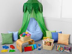 a child's play tent with toys and books on the floor next to it