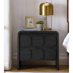 a black and gold sideboard with a potted plant on top next to it