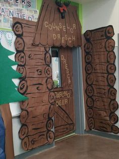 a classroom door decorated for christmas with trees and signs on the front wall, along with other decorations