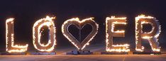 the word love spelled out with fire and sparkles in the shape of a heart