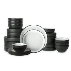 black and white dishes are stacked on top of each other