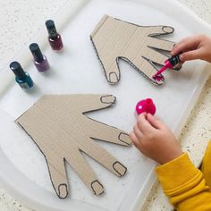 a child is cutting out paper with scissors and glues on the table next to some crafting supplies