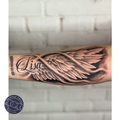 a man's arm with an angel wing tattoo and the word roma written in cursive writing