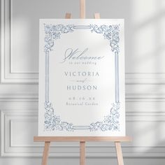 an easel with a wedding sign on it in front of a white wall and floor