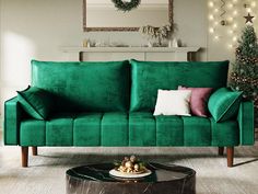 a living room with green velvet couches and christmas decorations