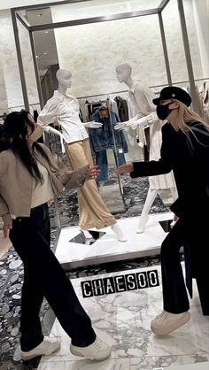 two women are looking at mannequins in a store