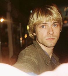 a man with blonde hair is looking at the camera