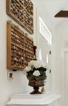 a vase filled with white flowers sitting on top of a counter next to a door