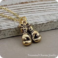 This Boxing Gloves Charm necklace comes on a gold-plated chain that is available in different lengths. Please choose your desired length from the drop-down menu when placing the item in your shopping cart. { CHARM DETAILS }★ Material: Pewter ★ Finish Color: Gold★ Measurements: 1/2" x 3/4"★ Dimensions: Two-sided★ Made in the USA{ SIMILAR ITEMS } More sports themed items available from my shop: https://www.etsy.com/shop/treasuredcharms/search?search_query=sports{ GIFT OPTIONS}Gift boxes are availa Brass Charm Necklace With Box Chain For Gift, Brass Charm Necklace With Box Chain As Gift, Adjustable Box Chain Charm Necklace For Gift, Gold Charm Necklaces With Box Chain For Gifts, Gold Charm Necklace With Box Chain For Gifts, Gold Charm Necklace With Box Chain As Gift, Pandora Beads, Boxing Gloves, Sports Gifts