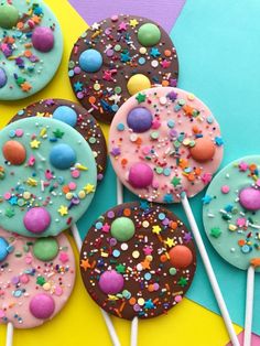 there are many decorated cookies and lollipops on the stick in front of them