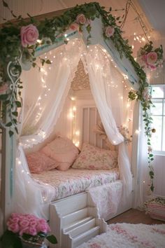 a white bed with pink flowers on the headboard and canopy, surrounded by fairy lights