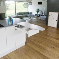 a modern kitchen with white cabinets and wood floors