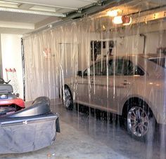 a car is parked in a garage with plastic covering the doors and windows on it's sides