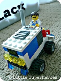 a lego man driving a toy truck on the floor