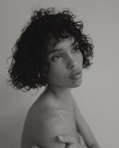 black and white photograph of a naked woman with curly hair looking off to the side