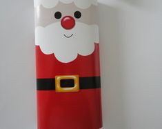 a red and white santa clause phone case with a gold buckle on the front, attached to a wall