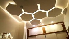 a room with some lights on the ceiling and hexagonal shapes painted on the walls