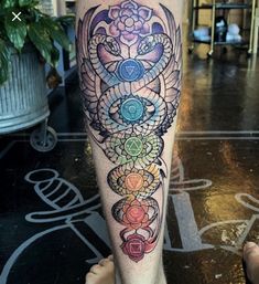 a person with a tattoo on their leg that has seven chakras in it