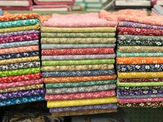 many different colored fabrics are stacked on top of each other