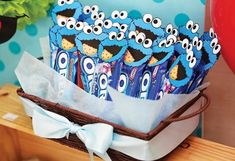 a basket filled with blue chocolate covered in cartoon character candies on top of a wooden table