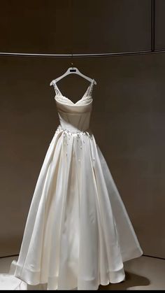 a white wedding dress hanging on a hanger