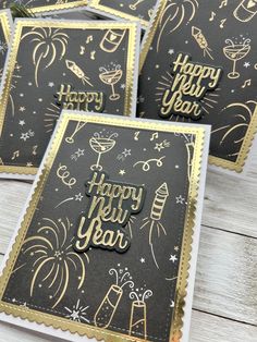 four black and gold new year cards with fireworks