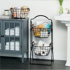 two baskets are stacked on top of each other in front of a sink and mirror