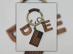 a pair of wooden keychains with the word e and an american flag on them