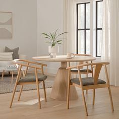 a dining table with two chairs and a potted plant