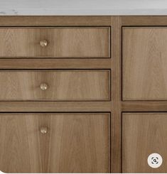 a close up of a wooden dresser with white marble counter top and drawers on each side