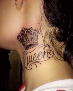 a woman's neck with a crown tattoo on her left side and the word queens written in cursive font