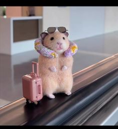 a hamster is standing on top of a conveyor belt holding a piece of luggage