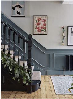 the stairs in this house are painted blue and have pictures above them on the wall