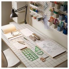 the table is covered with paper, scissors, and other crafting supplies on it