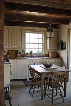 a kitchen with a table and chairs in it next to an open door that leads to the outside