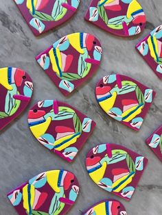 several colorful fish shaped cookies sitting on top of a table