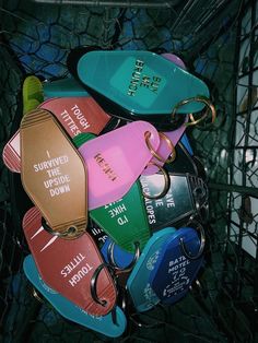 there are many different colored surfboards in the basket with tags on them, and one has a keychain attached to it