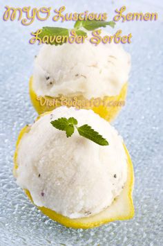 two lemon halves with ice cream and mint sprig on top, sitting on a blue surface