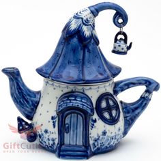 a blue and white teapot with a wizard hat on it's top, holding a bell