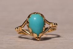 The Sandpiper Lane: Vintage Mid Century Yellow Gold Turquoise Ring. At the core of this design rests a pear-shaped cabochon with a mesmerizing robins egg blue turquoise, securely cradled within Fleur de Lis inspired prongs. Below the center stone, a graceful split shank elegantly merges, adorned with intricate granulations at its peak. Meticulously fashioned from 14-karat yellow gold, this ring captures the essence of the mid-century era with a touch of timeless beauty. Presently sized at 4.5, t Elegant Blue Turquoise Cabochon Ring, Elegant Turquoise Teardrop Ring For Anniversary, Elegant Turquoise Teardrop Rings, Mid Century Yellow, Gold Turquoise Ring, Turquoise Gold Ring, Heart Pendant Diamond, Robins Egg, Robins Egg Blue