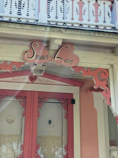 a pink and white building with an ornate doorway that says summer love on the front