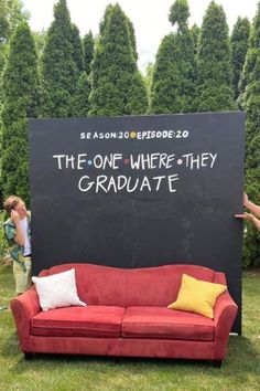 a red couch sitting in front of a blackboard with the words the one where they graduate