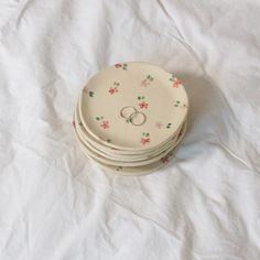 stack of four wedding rings sitting on top of each other in front of a white sheet