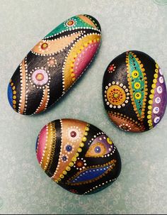 three painted rocks sitting on top of a table