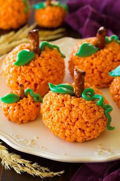 pumpkin rice krispy treats on a white plate with purple and green decorations around them