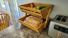 a kitchen counter with bread, fruit and an air fryer on top of it